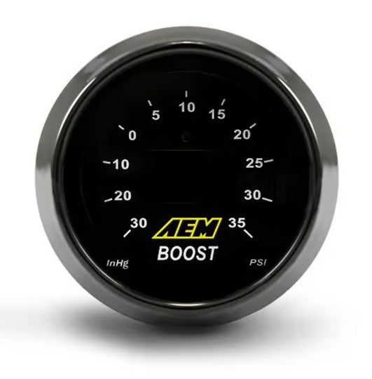 A circular automotive gauge with a black face, silver metallic bezel, white measurement markings, and a yellow AEM BOOST logo in the center, shown on a white background.