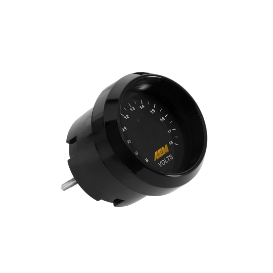 A black automotive voltmeter gauge with a silver metal terminal on the side, featuring white markings and a yellow &