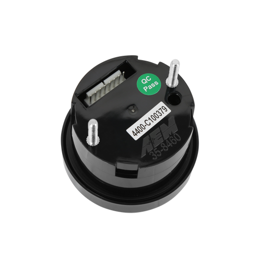 A black circular electronic component with three silver metal pins, a white label, a green &