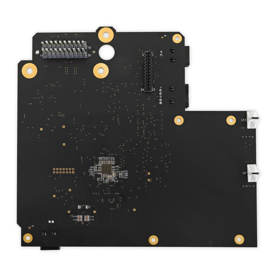 Close-up of a black electronic circuit board with gold connectors on a white background